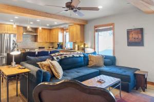 a living room with a blue couch and a kitchen at 3BR Townhome Incredible Location in Park City