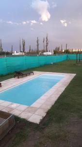 una piscina con una mesa de picnic y una valla en Estancia la juana en San Rafael