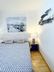 坎德拉里亞的住宿－MEERBLICK CALETILLAS，卧室配有一张床,墙上挂着一幅画