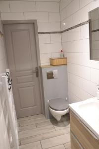 a white bathroom with a toilet and a sink at La Chaloupe gites de mer in Jullouville-les-Pins