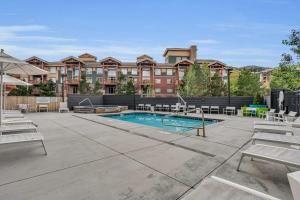 a patio with a swimming pool with chairs and a building at 1BR in the Heart of Canyons Village in Park City