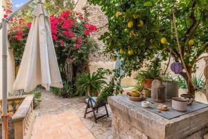 patio con tavolo, ombrellone e fiori di Ca na Perereta a Sencelles