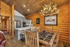 una sala da pranzo e una cucina con tavolo da pranzo e lampadario pendente. di Luxurious 2BDR in Deer Valley with Hot Tub a Park City