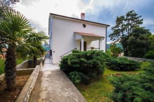 ein weißes Haus mit einer Palme und Büschen in der Unterkunft Studio für 4 Personen ca 40 qm in Rabac, Istrien Bucht von Rabac in Rabac