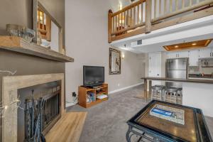 a living room with a fireplace and a tv at 2BD Condo with Ski Run Views and Hot Tub Access in Park City