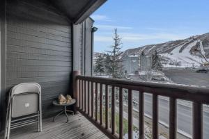 a balcony with a chair and a view of a snow covered mountain at 2BD Condo with Ski Run Views and Hot Tub Access in Park City
