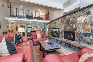 een woonkamer met een grote stenen open haard bij Ski in and out 4BDR Townhome with Aspen Views and Hot Tub in Park City