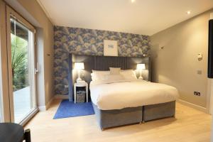 - une chambre dotée d'un grand lit avec un mur bleu dans l'établissement Luxurious villa south Dublin, à Dublin