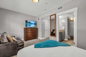 een slaapkamer met een bed, een bank en een televisie bij 3BD Olympic Park Condo on FREE Shuttle Line in Park City