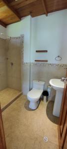 VILLA FLOREANA في Puerto Velasco Ibarra: حمام مع مرحاض ومغسلة