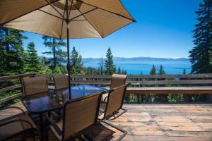 een tafel en stoelen met een parasol op een terras bij Carnelian Bay View Cabin in Carnelian Bay