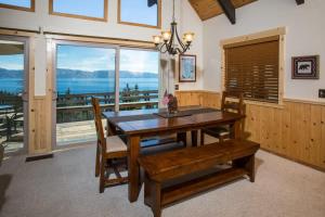 een eetkamer met een tafel en uitzicht op de oceaan bij Carnelian Bay View Cabin in Carnelian Bay