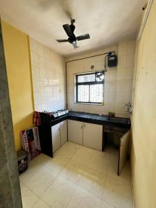 Il comprend une cuisine équipée d'un ventilateur de plafond et d'un évier. dans l'établissement F2 apartments, à Mumbai