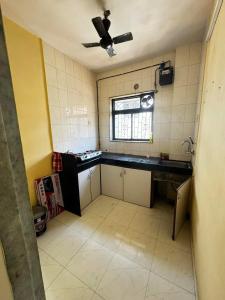 Il comprend une cuisine équipée d'un évier et d'un ventilateur de plafond. dans l'établissement F2 apartments, à Mumbai