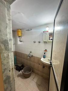 La salle de bains est pourvue d'une baignoire, d'un lavabo et de toilettes. dans l'établissement F2 apartments, à Mumbai