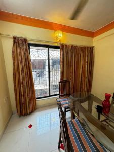 a living room with a glass table and a window at F2 apartments in Mumbai