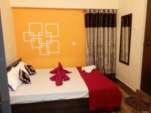 sypialnia z łóżkiem z czerwonym kocem w obiekcie Arangan kudil Family Stay w mieście Tiruchchirāppalli