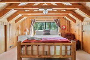 a bedroom with a large bed in a room with wooden walls at 3BR Mountain Cabin-Near Beach & Slopes in Homewood