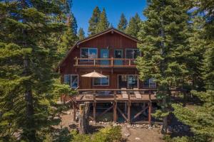 une grande maison en bois au milieu des arbres dans l'établissement 3BD Home with Panoramic Lake Tahoe Views, à Carnelian Bay