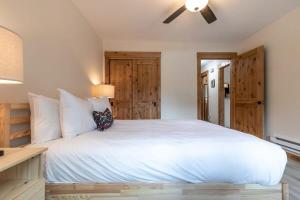 a bedroom with a white bed with a ceiling fan at One BDR in the Heart of Olympic Valley in Alpine Meadows