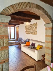 ein Wohnzimmer mit einem weißen Sofa und einer Steinmauer in der Unterkunft Studio für 7 Personen ca 90 qm in Pratovecchio, Toskana Provinz Arezzo in Pratovecchio