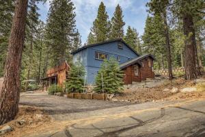 uma casa azul no meio de uma floresta em Classic 3BD Tahoe Cabin with Hot Tub em Carnelian Bay