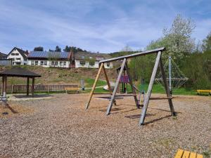 a swing set in a park with a playground at Les Papillons in Tennenbronn