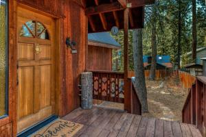 eine Haustür einer Hütte mit einem Baum in der Unterkunft Tranquil Tahoe A-Frame Walk to Beach in Tahoe Vista