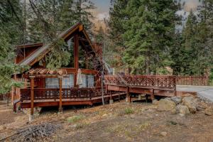 eine Hütte im Wald mit zwei Bänken davor in der Unterkunft Tranquil Tahoe A-Frame Walk to Beach in Tahoe Vista