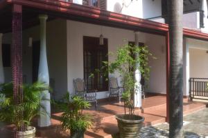 a porch of a house with plants in pots at Casa Winnie in Kelaniya