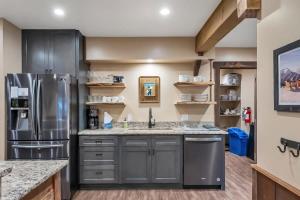 a kitchen with gray cabinets and a stainless steel refrigerator at 3BD with Hot Tub Two Minutes from King Beach in Tahoe Vista +36 photos