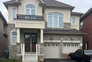 a house with a car parked in front of it at 4-Bedroom Serenity Retreat - Comfort & Style in Brampton