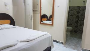 ein Schlafzimmer mit einem Bett und einem Spiegel sowie ein Badezimmer in der Unterkunft ONE NATION HOTEL Luxor in Luxor