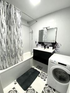 een badkamer met een wasmachine en een douchegordijn bij Charmante T3 sur la Côte d’Azur in Nice