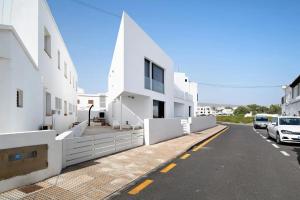 a white building with a parking lot next to a street at CASA ANCLADA en ARRIETA in Arrieta