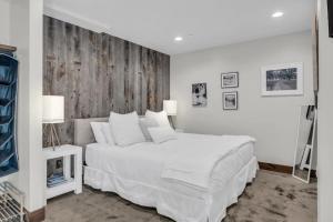 a white bedroom with a white bed and a wooden wall at 2BD Near Slopes and Town with Impressive Views in Park City