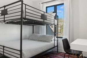a bedroom with two bunk beds and a chair at 2BDR New Build Minutes to Dillon Reservoir in Silverthorne