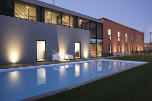 a swimming pool in front of a building at night at Casa de l Cura in Miranda do Douro