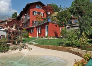 uma casa vermelha com uma piscina em frente em Affittacamere Belvedere em Sordevolo