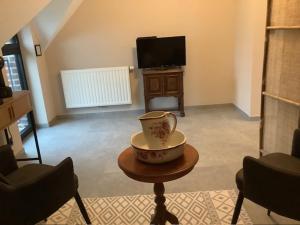 a living room with a vase sitting on a table at B&B Schaliëndak in Kortenberg