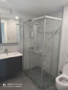 a bathroom with a shower and a toilet at Comfy, Luxury Flat for All Ages in Iskele