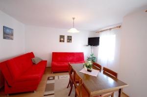 een woonkamer met een rode bank en een tafel bij Ferienwohnung für 4 Personen ca 37 qm in Njivice, Kvarner Bucht Krk - b58789 in Njivice