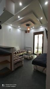 - un salon avec deux lits et une fenêtre dans l'établissement Farah, à El Madania