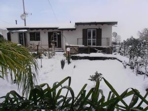 a house with a snow covered yard in front of it at La Rosa dell'Etna in Castiglione di Sicilia