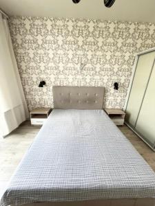 a bedroom with a bed in a room with wallpaper at Most City Area Pearl Apartment in Dnipro