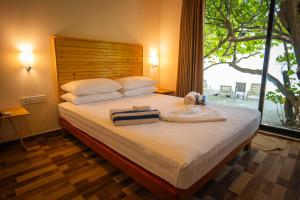 a bedroom with a large bed with a large window at Paguro Seaview in Bodufolhudhoo