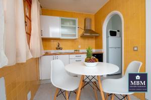 una pequeña cocina con mesa blanca y sillas en Ferienwohnung für 2 Personen 1 Kind ca 54 qm in Agaete, Gran Canaria Westküste Gran Canaria, en Agaete
