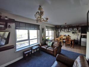 ein Wohnzimmer mit einem Sofa und einem Esszimmer in der Unterkunft Seashell Cove Bundoran Luxurious Sea View Free Wifi Netflix Sleeps 5 in Bundoran