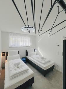 een slaapkamer met 2 bedden en een grote kroonluchter bij Xzllenz - 4 Schlafzimmer, Zentral, Parken, U-Bahn, 2 Bäder, 4 Smart-TV, optional Einzelbett in Neurenberg