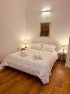 una camera da letto con un letto bianco con due asciugamani sopra di La Gioconda Exclusive Suite a Bari